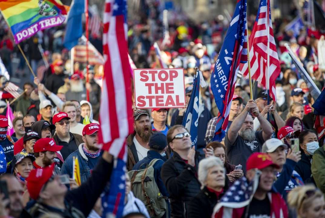 Crowd with flags and "Stop the Steal" sign.