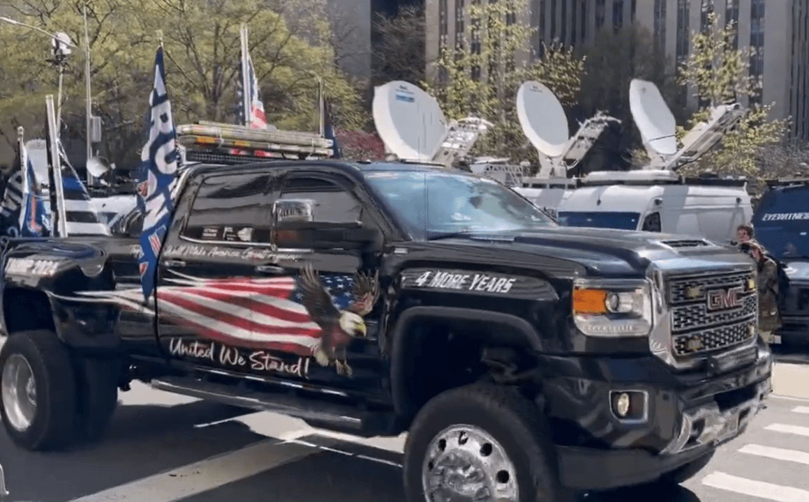 Truck with American flags in a parade.