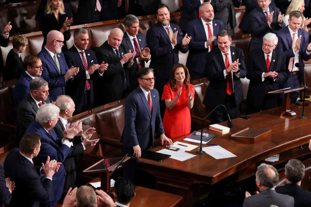 Group of people applauding in a meeting room.